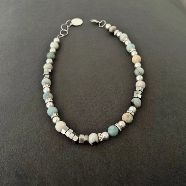 Ett snyggt armband med amazonit stenar i toner av vitt, grått, beige och turkos. Smycket pryds även av fina detaljer med inslag av strass-stenar.