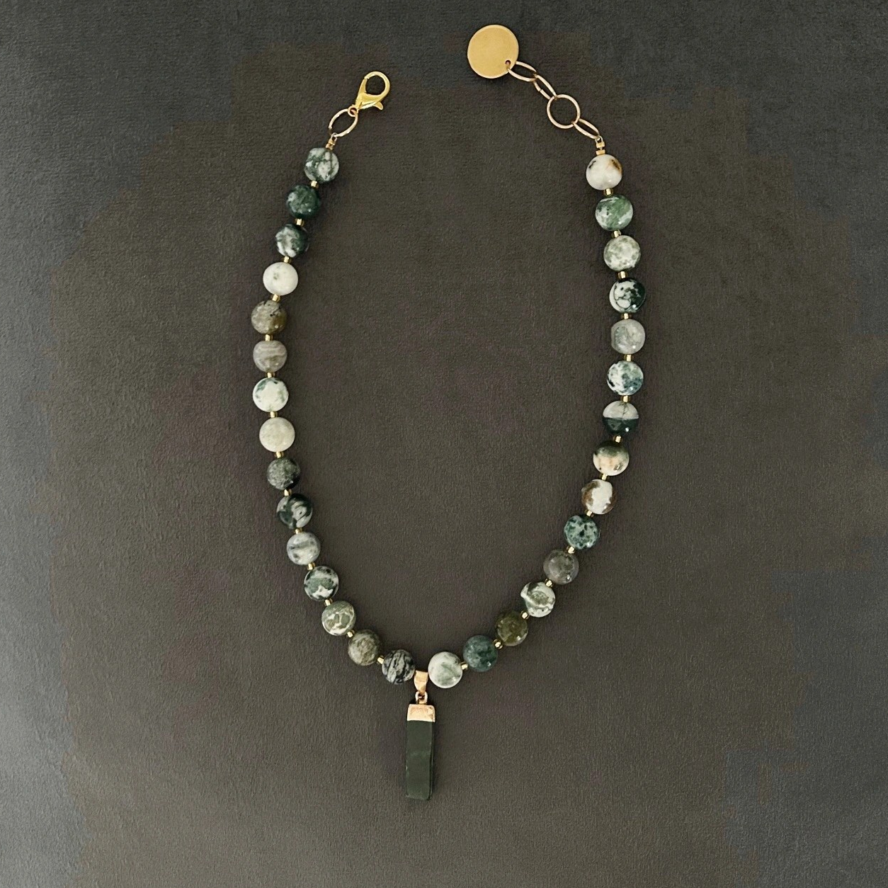 Halsband med naturträds-agat (halvädelsten) med vackra skiftningar i grönt, vitt och grått. Halsbandet pryds också av ett dekorativt hänge i moss-agat.