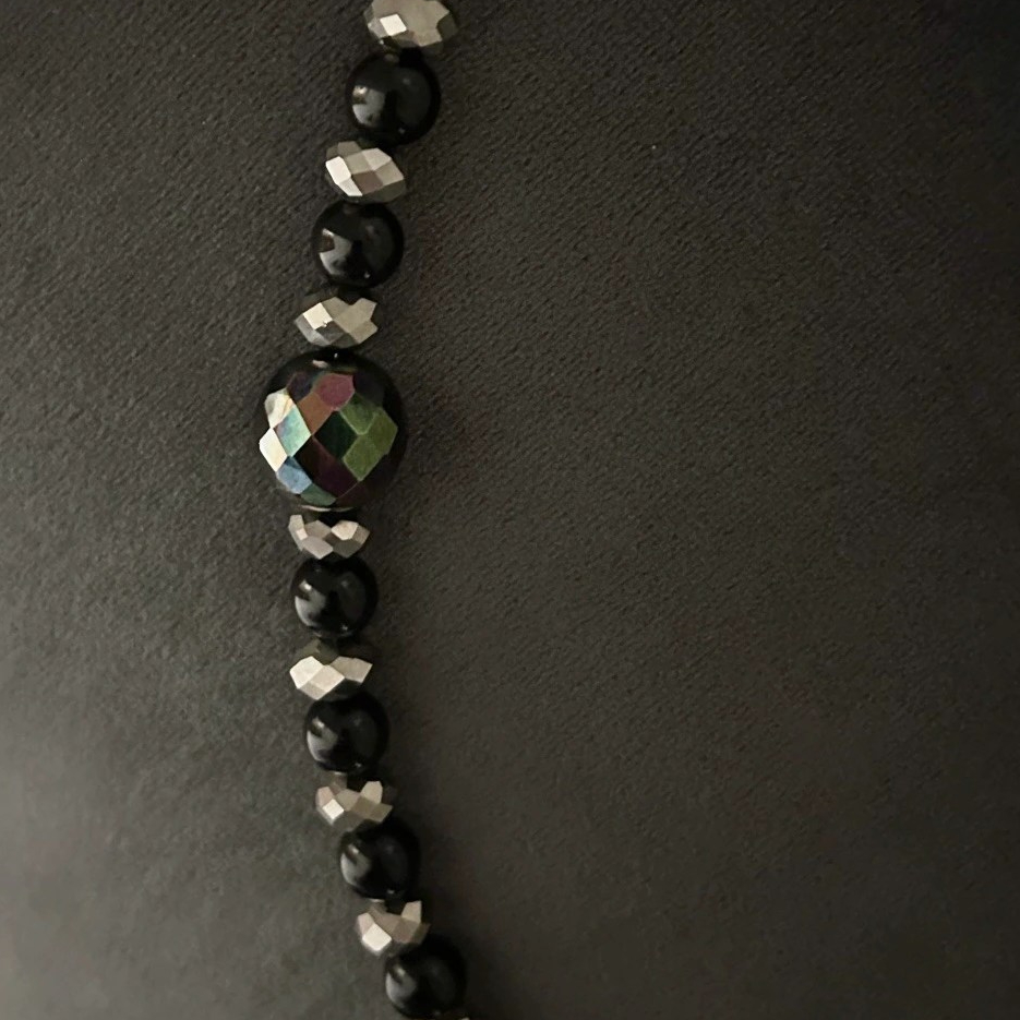 Ett Halsband i rockig design med toner i svart och silver. En berlock med döskalle i strass förser smycket med ytterligare en snygg detalj.