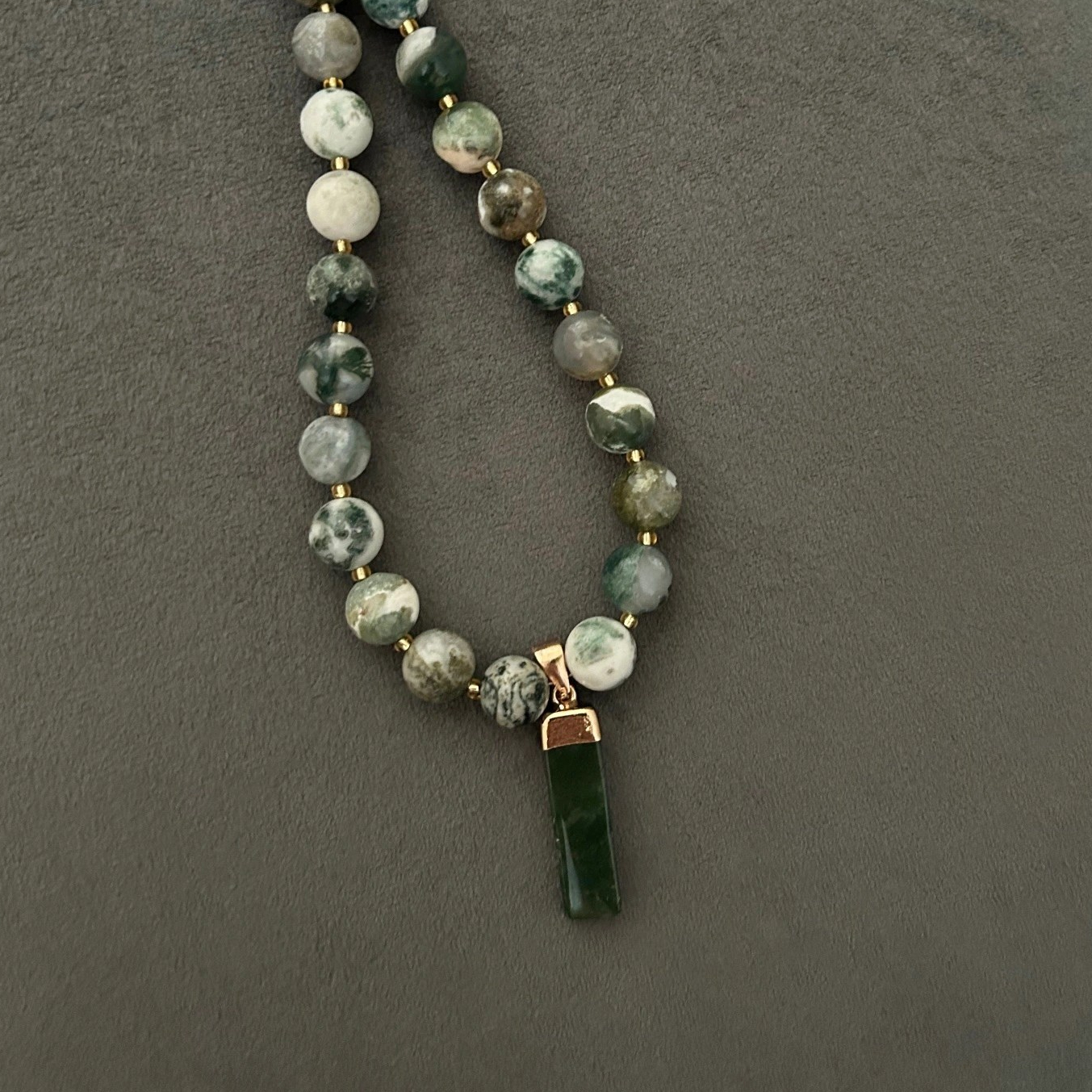 Halsband med naturträds-agat (halvädelsten) med vackra skiftningar i grönt, vitt och grått. Halsbandet pryds också av ett dekorativt hänge i moss-agat.