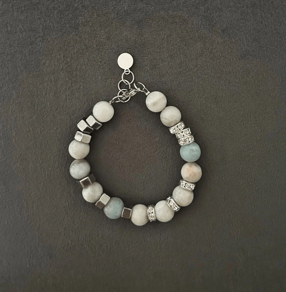 Ett snyggt armband med amazonitstenar i kombination av agatstenar i toner av vitt, grått, beige och turkos. Smycket pryds även av fina detaljer med inslag av strass-stenar.