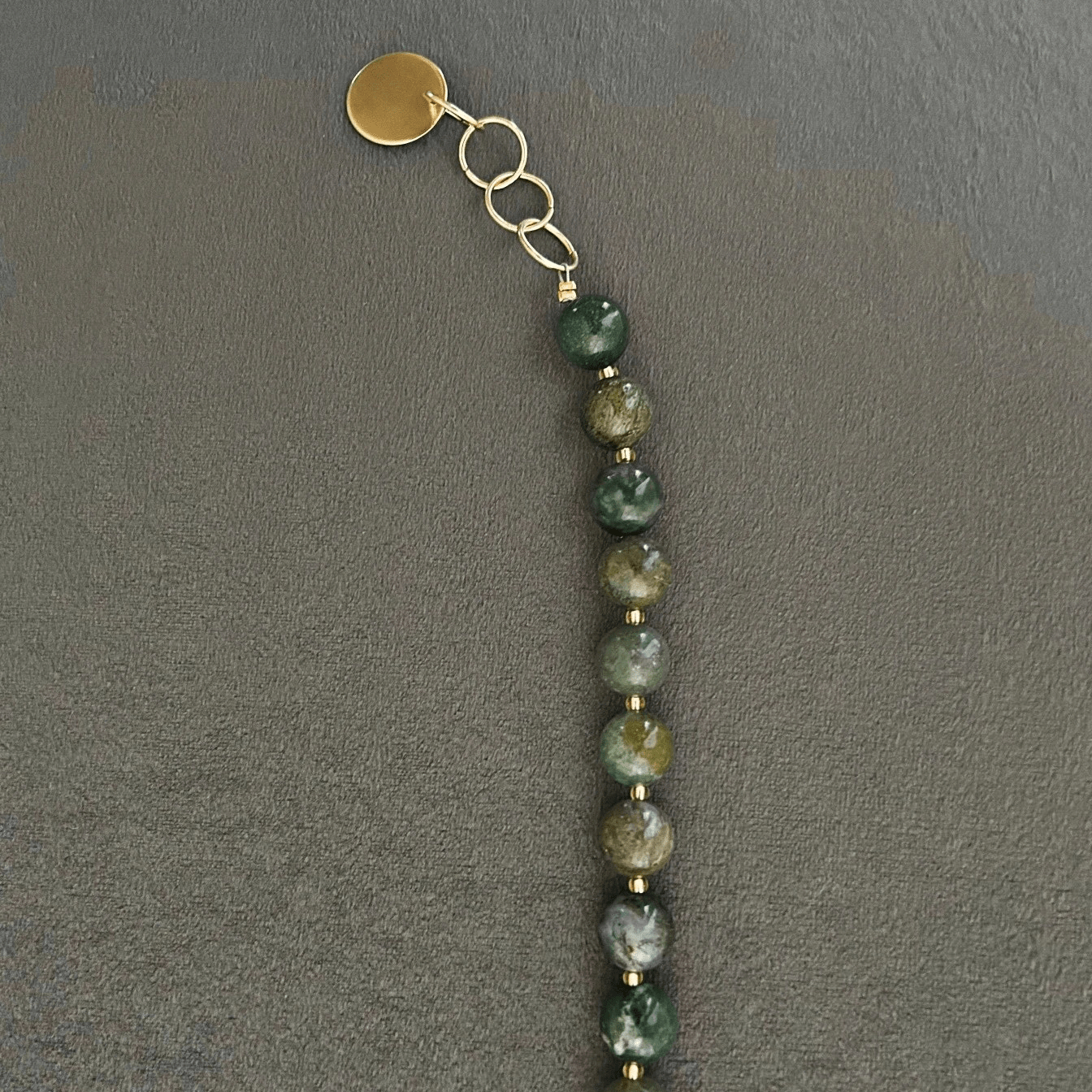 Halsband med halvädelstenar (agatsten), detta förgylls med indiska naturstens-agater. Smycket går i jordnära toner med skiftningar i lila och grå, med inslag av jadesten i rosa ton. Halsbandet pryds också med ett hänge i vacker rosenkvarts.