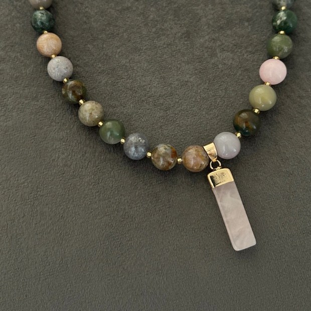 Halsband med halvädelstenar (agatsten), detta förgylls med indiska naturstens-agater. Smycket går i jordnära toner med skiftningar i lila och grå och med inslag av jadesten i rosa ton. Halsbandet pryds också med ett hänge i vacker rosenkvarts.