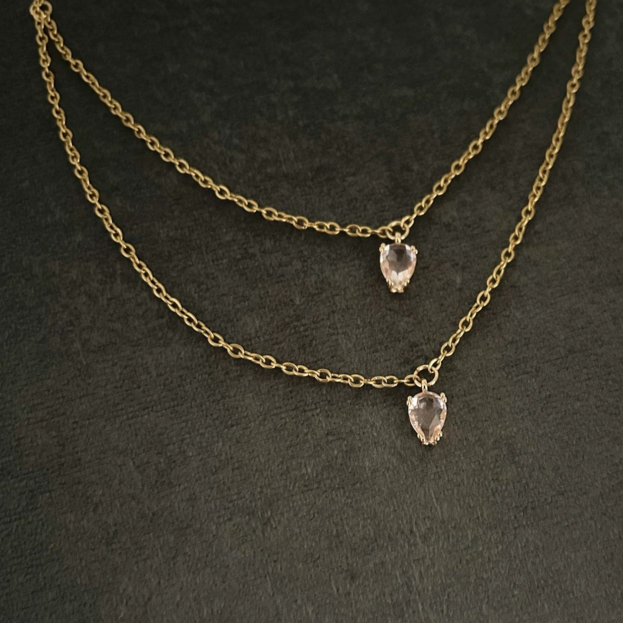 Ett prydligt halsband i smal guldkedja och dekorativ glassten i rosa nyans.