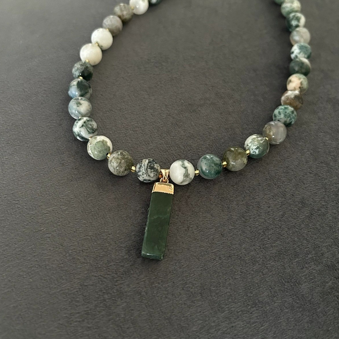 Halsband med naturträds-agat (halvädelsten) med vackra skiftningar i grönt, vitt och grått. Halsbandet pryds också av ett dekorativt hänge i moss-agat.