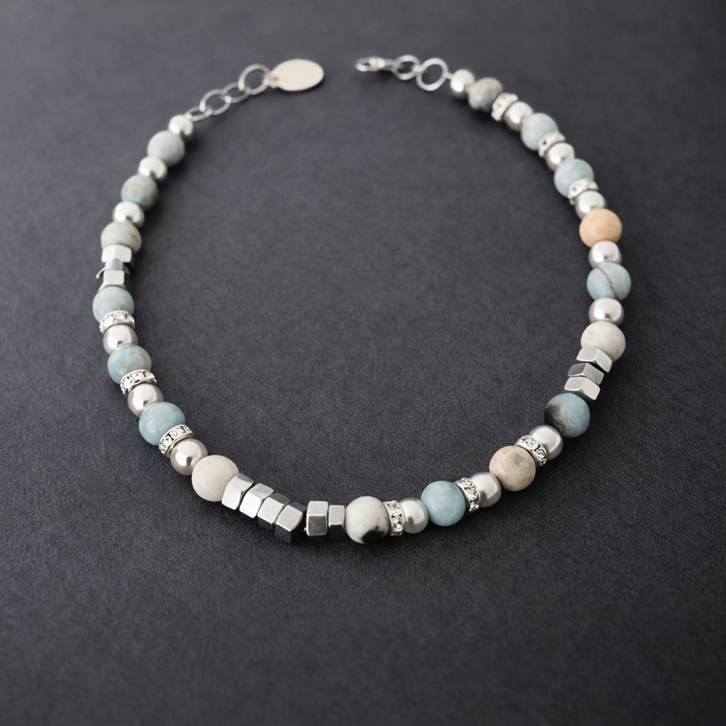 Ett snyggt armband med amazonit stenar i toner av vitt, grått, beige och turkos. Smycket pryds även av fina detaljer med inslag av strass-stenar.